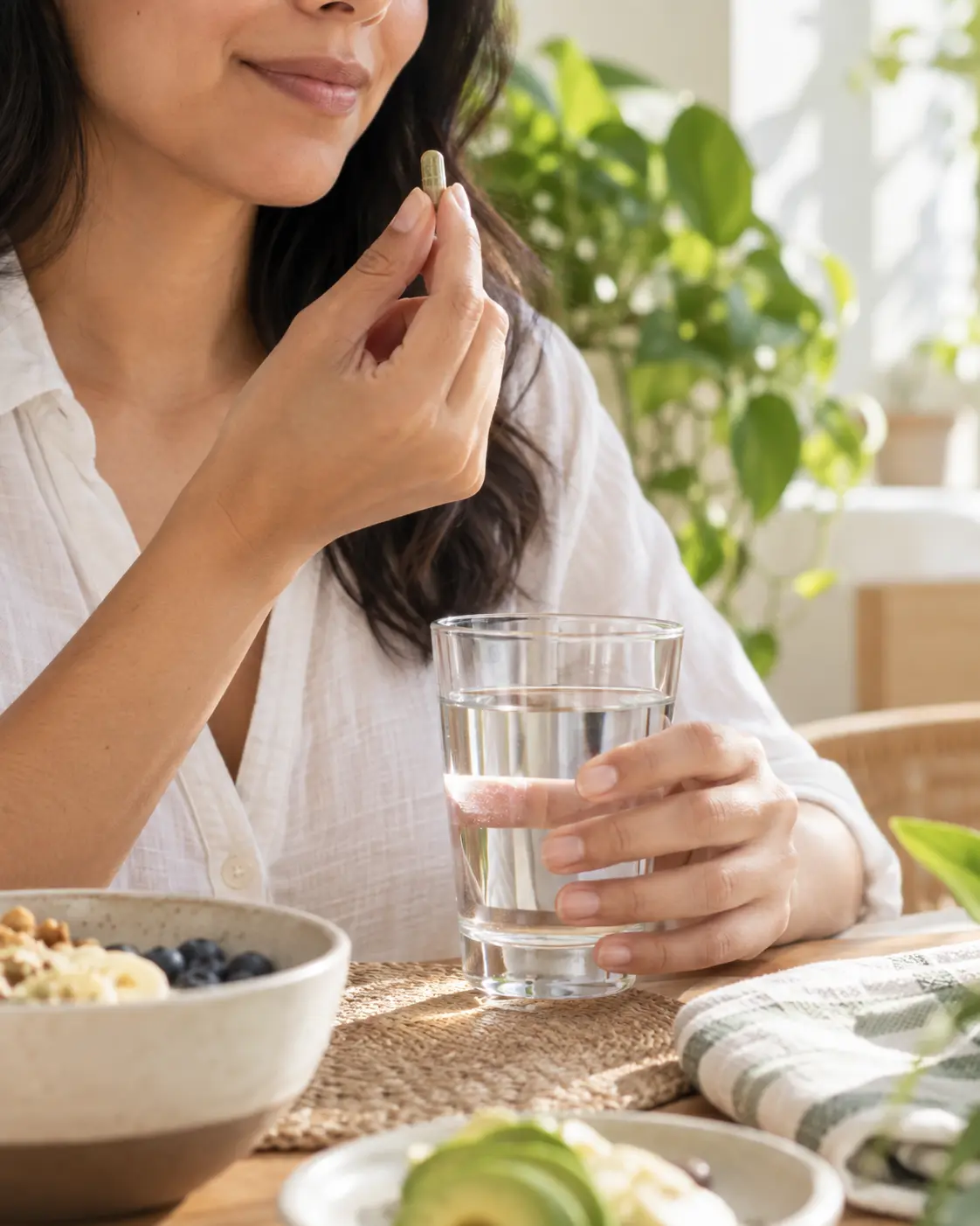 Cápsula y vaso de agua en una rutina de bienestar